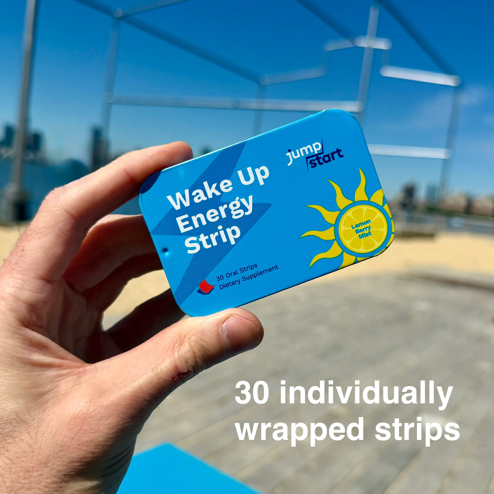 Hand holding a 'Wake Up Energy Strip' package with a cityscape in the background