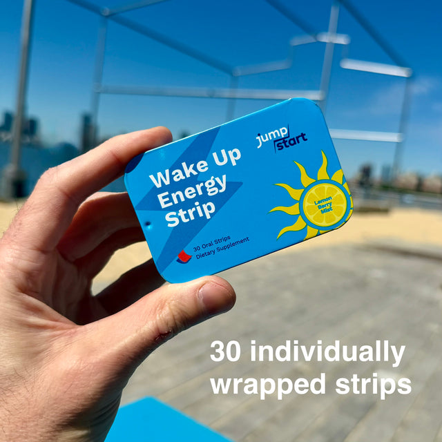 Hand holding a 'Wake Up Energy Strip' package with a cityscape in the background